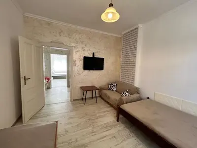 a living room with a couch and a tv on the wall at Smile House in Plovdiv