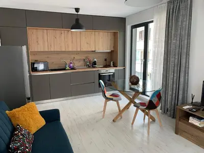 a living room with a table and a kitchen at Kirmini apartment in Sofia