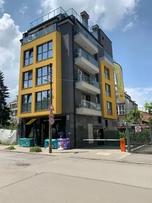 a yellow and black building on the corner of a street at Kirmini apartment in Sofia