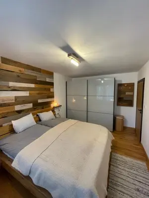 a bedroom with a large bed and a wooden wall at Borovets Boutique Apartment Sequoia II in Borovets
