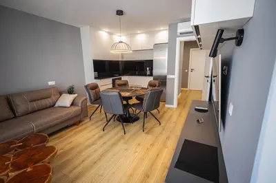 a living room with a couch and a table at Gran Capital - Vodolei Park, FREE parking in Sofia