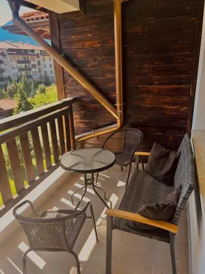 a balcony with two chairs and a table and chairs at View Apartment Bansko Royal Towers in Bansko