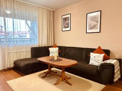 a living room with a black couch and a table at View Apartment Bansko Royal Towers in Bansko