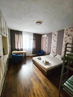 a bedroom with a bed and a table and a desk at Апартамент Лилия in Gotse Delchev