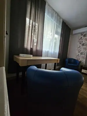 a table and a blue couch in a room at Апартамент Лилия in Gotse Delchev