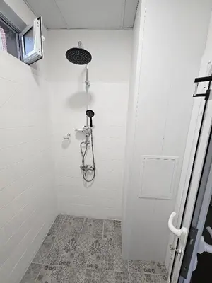 a white bathroom with a shower with at Апартамент Лилия in Gotse Delchev