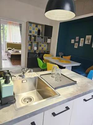 a kitchen with a sink and a living room at Апартамент Лилия in Gotse Delchev