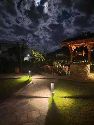 a walkway with lights in a yard at night at SPA Apartament Daffi in Smolyan