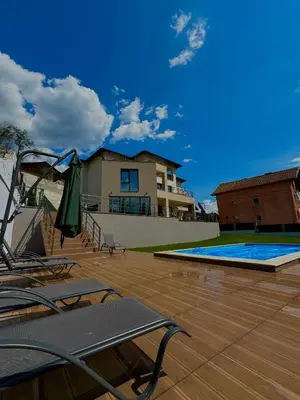 a patio with chairs and a pool and a building at The Hillside Villa in Ognyanovo