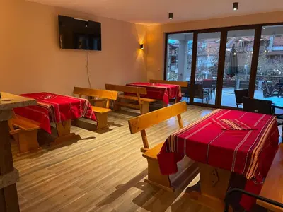 a restaurant with two tables and benches and red blankets at The Hillside Villa in Ognyanovo