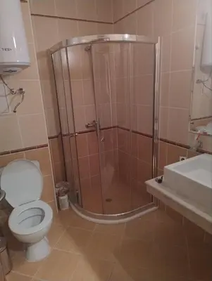 a bathroom with a shower with a toilet and a sink at Apartment near by Studenec-Cedar Heights 1 in Pamporovo