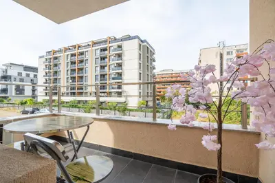 a apartment balcony with a table and a tree at Cardinal Suite in Sofia