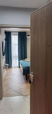 a bedroom with a bed and a door with a mirror at Apartmenthaus Oborishte - 24 in Panagyurishte
