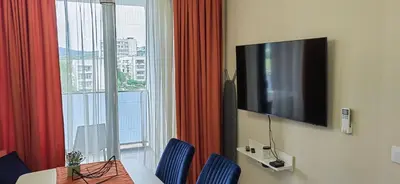 a room with a table and a tv and a window at Apartmenthaus Oborishte - 24 in Panagyurishte