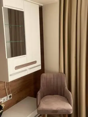 a chair sitting in a room with a window at Бутиково студио Joy-free parking in Plovdiv
