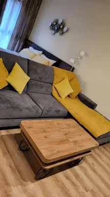 a living room with a grey couch with yellow pillows at Diamond of Crown Bansko by Flat Mаnager in Bansko