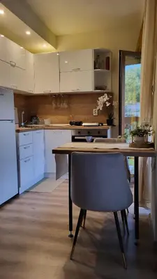 a kitchen with a table and a chair in it at Diamond of Crown Bansko by Flat Mаnager in Bansko