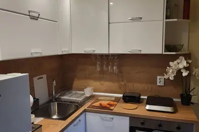 a kitchen counter with white cabinets and a sink at Diamond of Crown Bansko by Flat Mаnager in Bansko