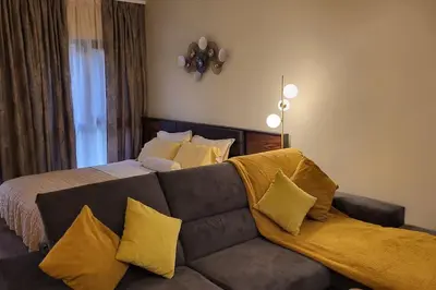 a bedroom with a couch with yellow pillows at Diamond of Crown Bansko by Flat Mаnager in Bansko