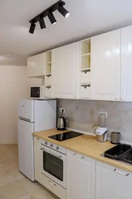 a kitchen with white appliances and white cabinets at Sophie Studio - Top center, Cozy & Work-Friendly near AUBG, Free streaming platforms in Blagoevgrad