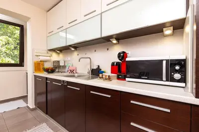 a kitchen with brown cabinets and a microwave at Quiet Apartment in Plovdiv Ricky Home in Plovdiv