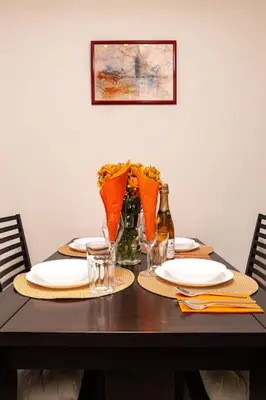 a table with plates and glasses and flowers on it at Quiet Apartment in Plovdiv Ricky Home in Plovdiv