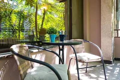 a table and chairs on a porch with a window at Quiet Apartment in Plovdiv Ricky Home in Plovdiv