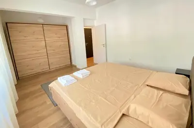 a bedroom with a bed and a large wooden door at Удобен апартамент в центъра на София in Sofia