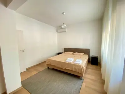 a bedroom with a bed in a white room at Удобен апартамент в центъра на София in Sofia