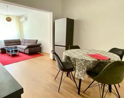 a living room with a table and a couch at Удобен апартамент в центъра на София in Sofia