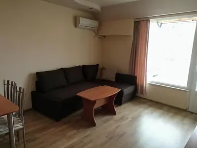 a living room with a black couch and a table at Apartments Center in Sandanski