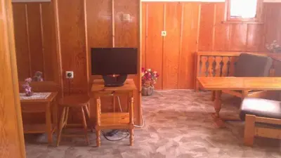 a living room with a tv and a desk with a computer at Matsureva House - Pri Ivan in Bansko