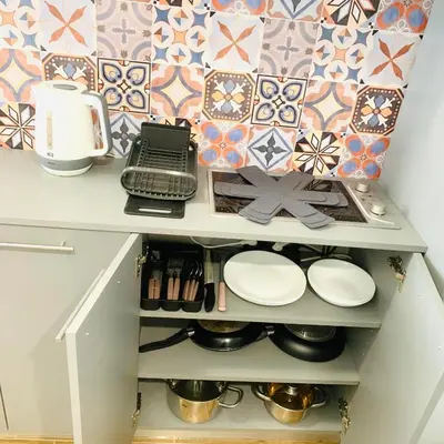 a cupboard with plates and pans in a kitchen at Little Paris with Free Garage Near Tokuda Hospital in Sofia