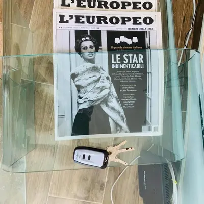 a magazine and a cell phone on a glass table at Little Paris with Free Garage Near Tokuda Hospital in Sofia