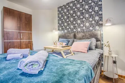 a bedroom with a bed with blue sheets and a table at Cosy Apartment On The Lift in Bansko