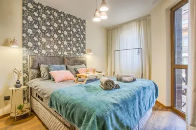 a bedroom with a large bed with a blue blanket at Cosy Apartment On The Lift in Bansko