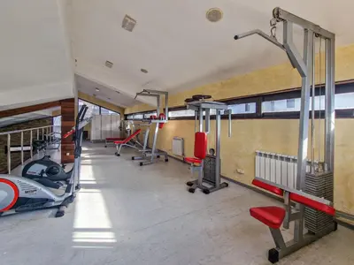 a gym with treadmills and machines in a building at Cosy Apartment On The Lift in Bansko