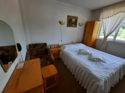 a bedroom with a bed and a table and a desk at Zodiac House in Samokov