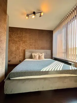 a bedroom with a bed with a ceiling fan at Business Park Sofia Cozy Lux & Private Garage Option in Sofia