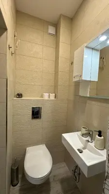 a bathroom with a white toilet and a sink at Скобелев 48 in Sofia