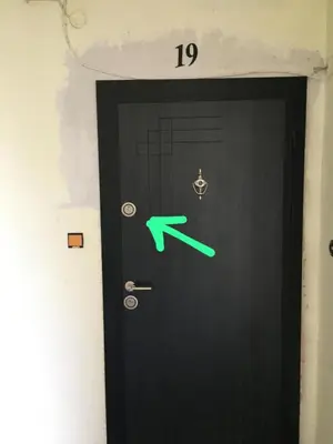 a black door with a green arrow on it at Скобелев 48 in Sofia