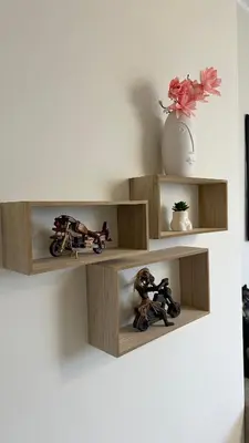 a wall with wooden shelves with toy motorcycles and a vase at Скобелев 48 in Sofia