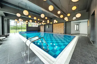 a large swimming pool with blue tiles in a building at Bansko Cozy Peak in Bansko