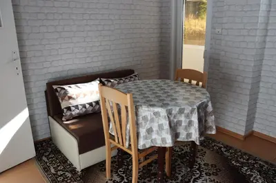 a table and a chair in a room with a couch at Apartment Nataliya in Smolyan