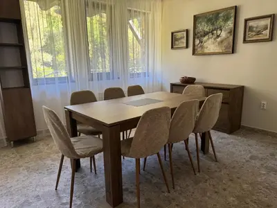 a dining room with a wooden table and chairs at Къща за гости Лъките in Divchovoto