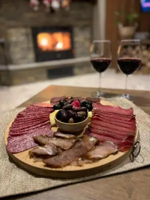 a plate of food and two glasses of wine at Къща за гости Лъките in Divchovoto