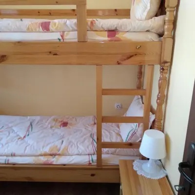 two bunk beds in a room with a desk at Tainov House in Samokov