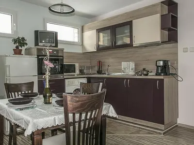a kitchen with a table and a dining room at АПАРТАМЕНТ ЗА ГОСТИ 