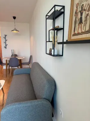 a living room with a blue couch and a table at MyCampus UNWE Studentski Mountain Views Modern Kitchen Equipment in Sofia