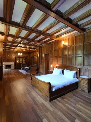 a bedroom with a large bed in a room with wooden walls at The Castle - Your unique way of retreat in Borovets